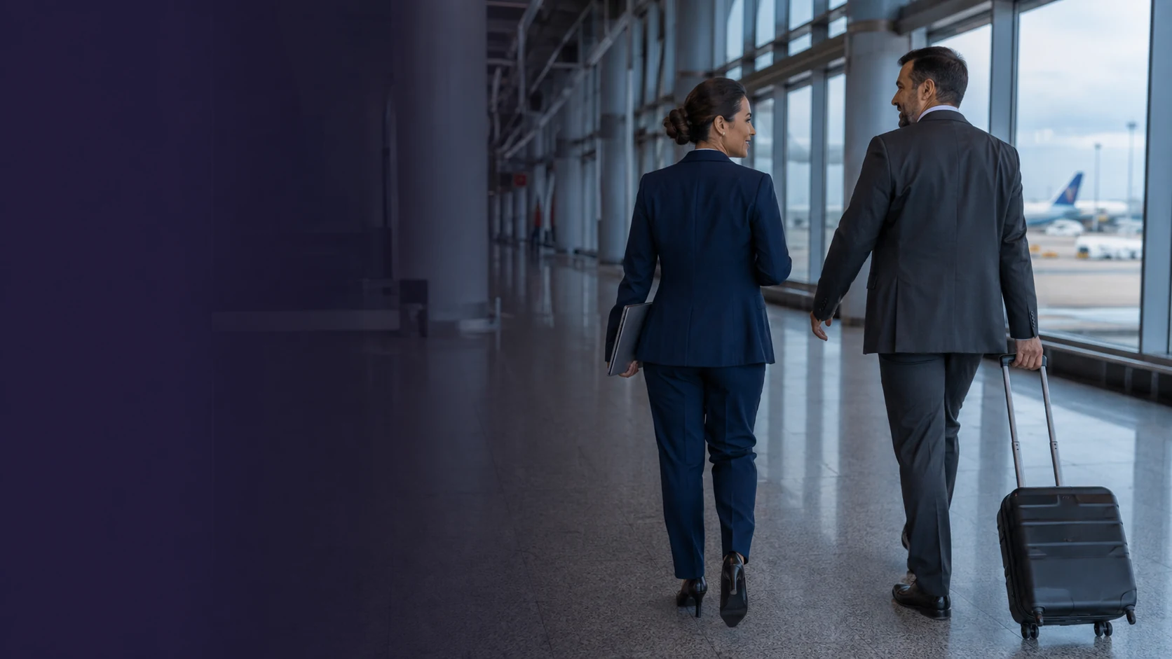 Profissionais em uma viagem corporativa, caminhando com bagagem em um terminal de aeroporto